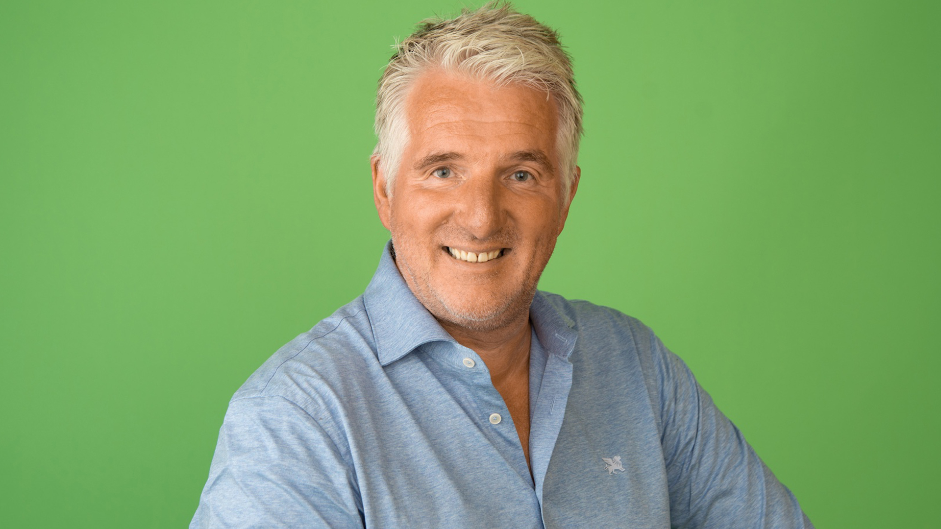 man in het blauw met een groene achtergrond