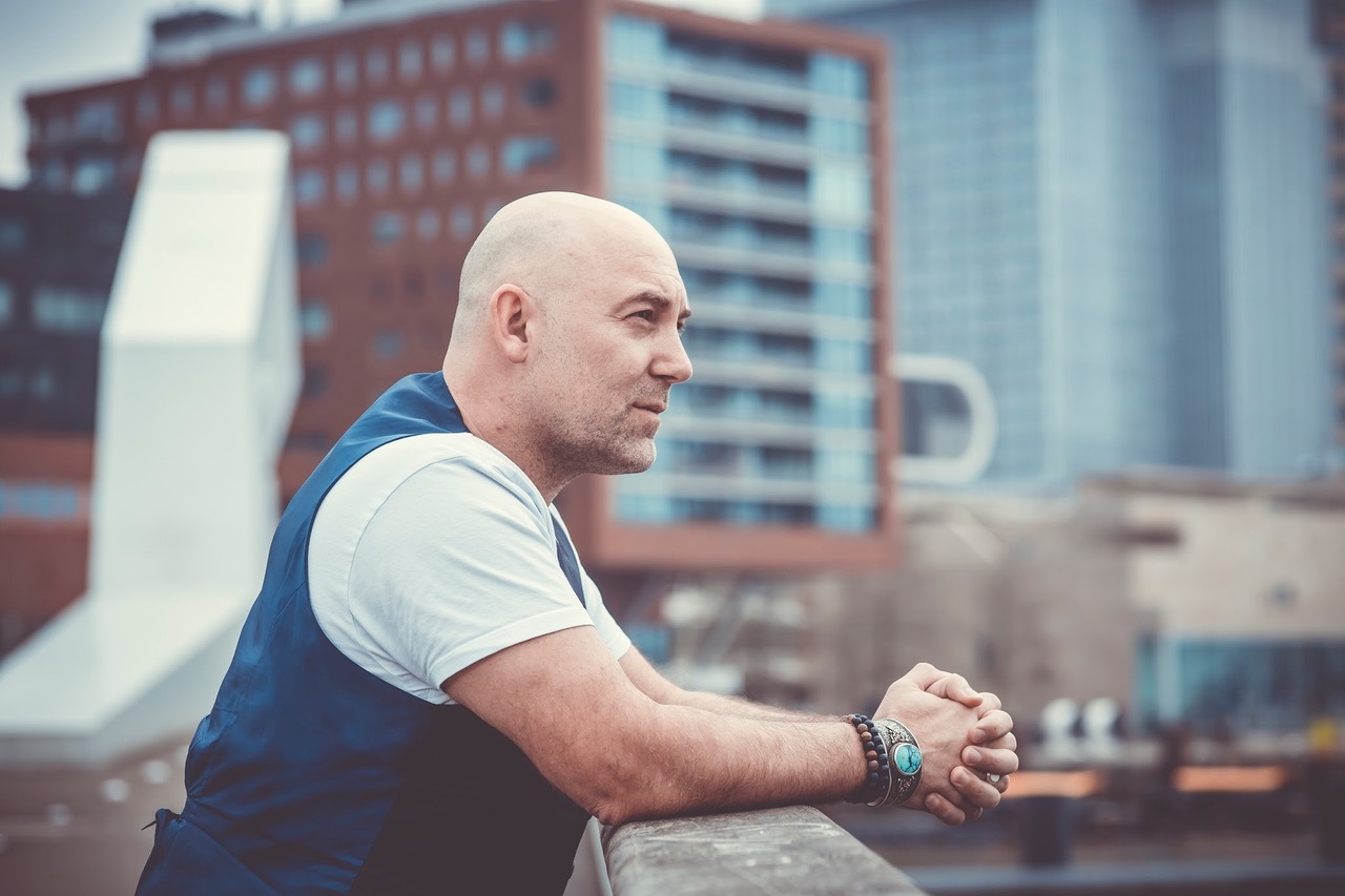 Loek Peters buiten met handen leunend op een balk