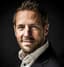Christian Kromme starend naar voren met een lichte glimlach.