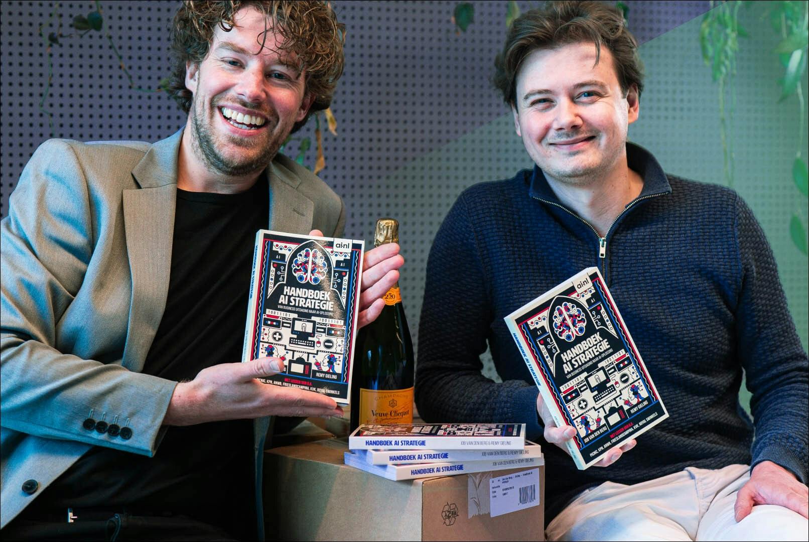 Job van den Berg en Remy Gieling glimlachend met boek in handen